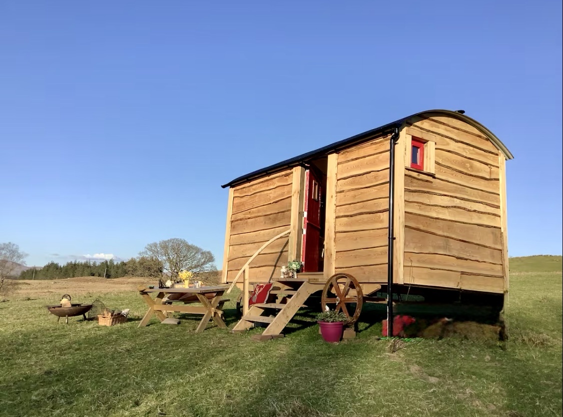 Stunning traditional shepherd hut in field with sheeps 